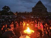 People gather at the Eternal Flame at the Shrine of Remembrance for the Anzac Day dawn service in 2017